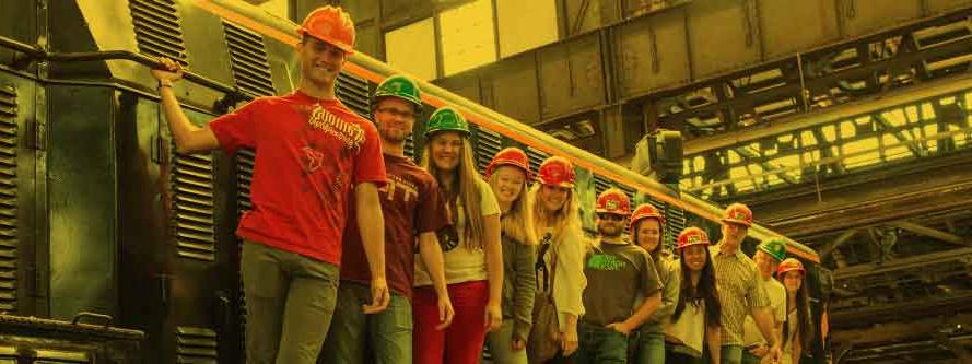 Students and faculty standing on the side of a locamotive